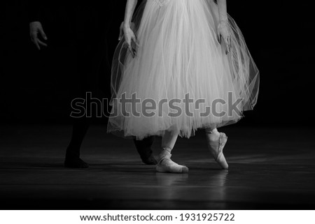 Closeup of ballerina dancing isolated on stage. Ballerina legs closeup