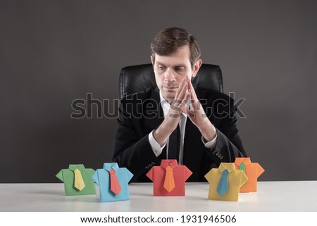 Personnel change. The boss reflects on the background of colorful origami men. Career ladder. Rational use of labor resources. HR manager.  Royalty-Free Stock Photo #1931946506