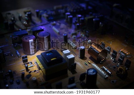 Creative concept of modern technology, inside an electronic device. Electronic circuit board close up in low key. Selective focus