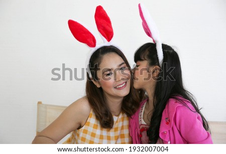 Happy easter event! family mother and child daughter with ears getting ready for holiday. Kid kiss mom with love. 