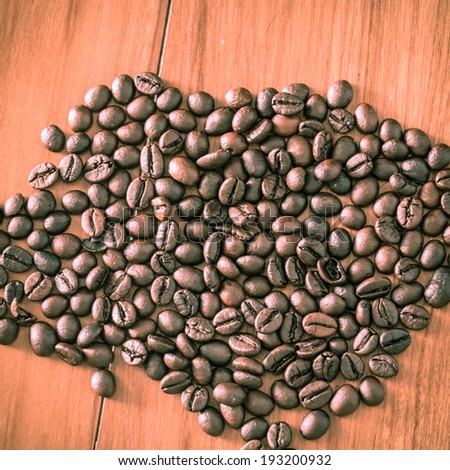 Coffee beans on wood background. Retro filter.