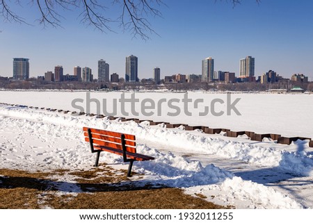 A bench along the shore of the Milwaukee, Wisconsin Harbor waits for springtime visitors
