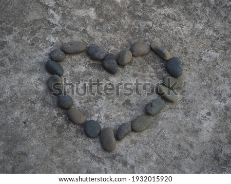 The stones on the cement floor are arranged in the shape of hearts for Valentine's Day.