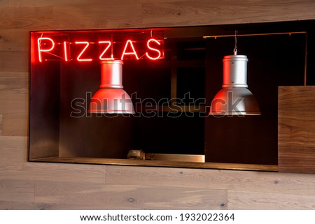 Neon gas pizza symbol or sign or Red neon gas advertising in restaurant