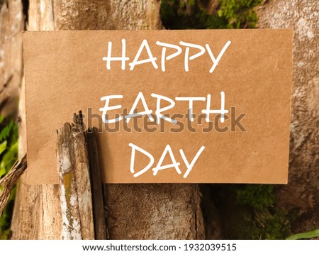 Selective focus.Blur word HAPPY EARTH DAY on blur brown paper with blur nature background.