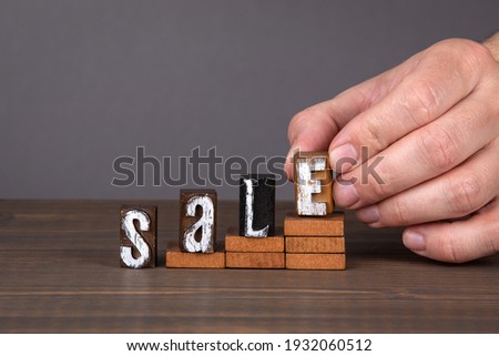 SALE. Business, development and growth concept. Alphabet letters on a wooden table
