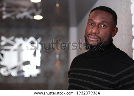 Thoughtful fit muscular black man in sweater with turtle neck leaning to the wall. Domestic photo at home. People lifestyle concept. Handsome Black Man's Portrait. Male Self-Confidence Concept Royalty-Free Stock Photo #1932079364