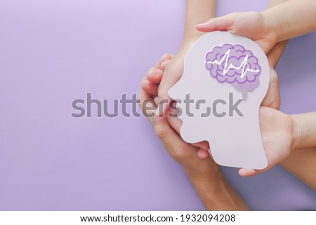 Adult and child hands holding encephalography brain paper cutout,autism, Stroke, Epilepsy and alzheimer awareness, seizure disorder, stroke, ADHD, world mental health day concept Royalty-Free Stock Photo #1932094208