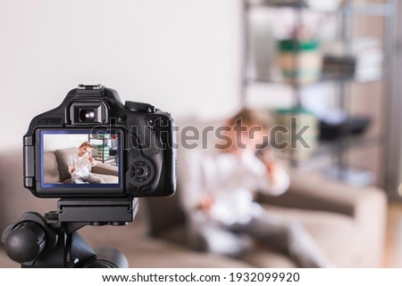 Vlogger recording social media video while sitting on the couch