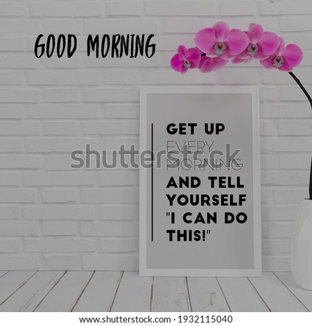 get up every morning and tell yourself "I can do this" good morning, a frame, pink flowers, on the wooden table and white colored bricks wall in background