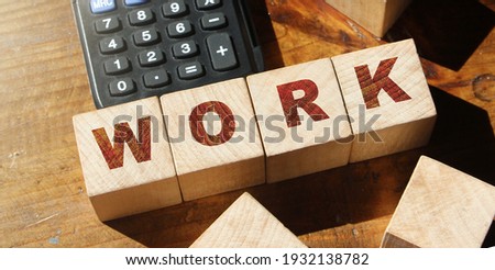 Work word made with wooden blocks on desk with calculator. Business career concept.