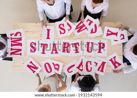 Multi-ethnic group of diverse people putting letters startup start up start-up teamwork cooperation concept