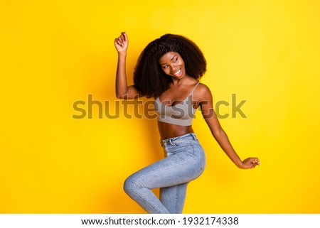 Photo of flirty lady look side empty space open mouth raise hand wear grey cropped top isolated yellow color background