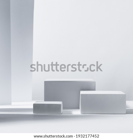 Elegant modern geometric style of showcase for cosmetics product display - white podiums as winner in sunlight with shadow in white background, square. 
