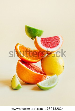 pyramid of citrus fruits grapefruit, orange, lemon, lime on yellow background Royalty-Free Stock Photo #1932182834