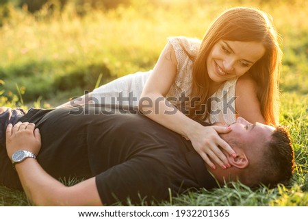 Couple lovers hugging and kissing in the park at sunset. Love, youth, happiness concept.