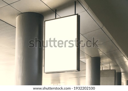 Blank white signage suspended from the ceiling in the airport terminal. Mock up