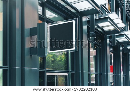 Black square signboard with blank space for your logo on the wall of a modern business center, mockup