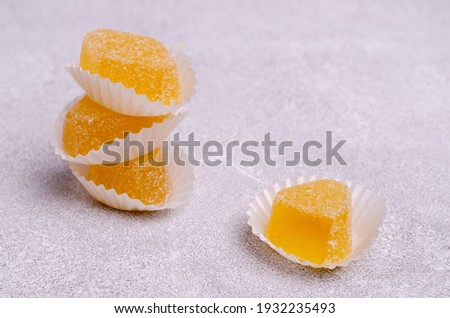 Yellow jelly candies on a gray cement background. Selective focus.