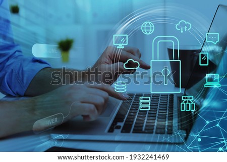 Businesswoman with laptop, desktop at office interior, blue glowing information protection icons. Padlock and business data symbols. Concept of cyber security and data storage Royalty-Free Stock Photo #1932241469