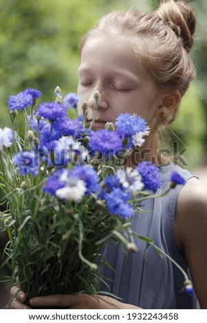 spring mood. girl holding a bouquet of centaurea
