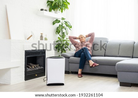 elderly woman next to an air purifier moving to a new apartment