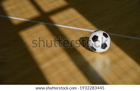 Soccer and futsal ball on hardwood court floor with natural lighting. Indoor soccer futsal ball. Team sport. Workout online concept