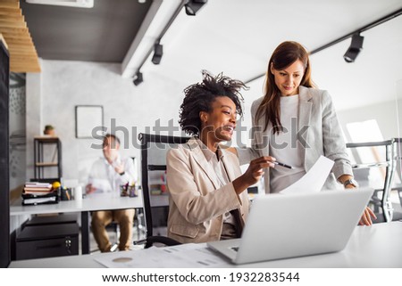 Two brunette business woman, talking, advising each other. Royalty-Free Stock Photo #1932283544