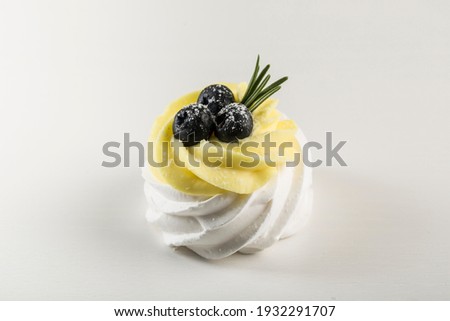 Pavlova dessert with lemon cream and blueberries on a white background, isolated. Close-up with a copy space for the text. Horizontal orientation.