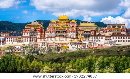 Ganden Sumtseling monastery main buildings scenic view with golden roofs surrounded by green nature in Shangri-La Yunnan China Royalty-Free Stock Photo #1932294857