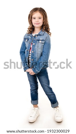Portrait of adorable smiling little girl in jeans isolated on a white Royalty-Free Stock Photo #1932300029