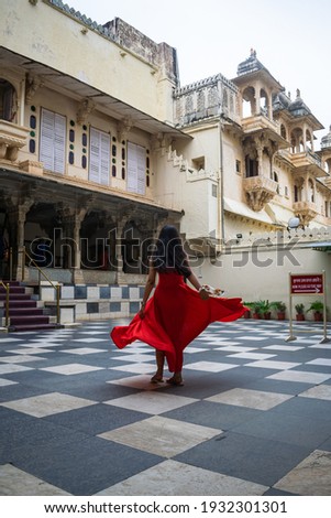 girl in a red dress dancing in city palace