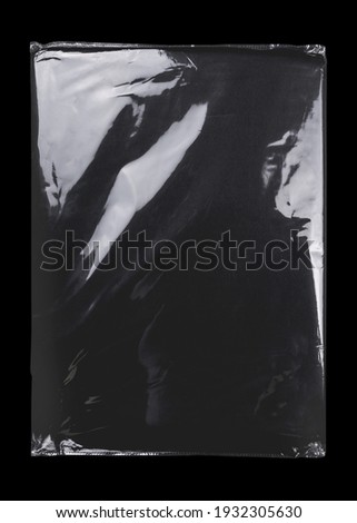 Transparent plastic wrap on the black background. Clean blank texture overlay effect template. Isolated wrinkle surface branding mock-up. Black pack packaging bag. Royalty-Free Stock Photo #1932305630