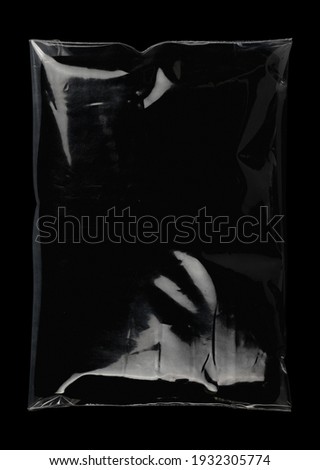Transparent plastic wrap on the black background. Clean blank texture overlay effect template. Isolated wrinkle surface branding mock-up. Black pack packaging bag. Royalty-Free Stock Photo #1932305774