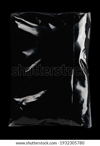 Transparent plastic wrap on the black background. Clean blank texture overlay effect template. Isolated wrinkle surface branding mock-up. Black pack packaging bag. Royalty-Free Stock Photo #1932305780