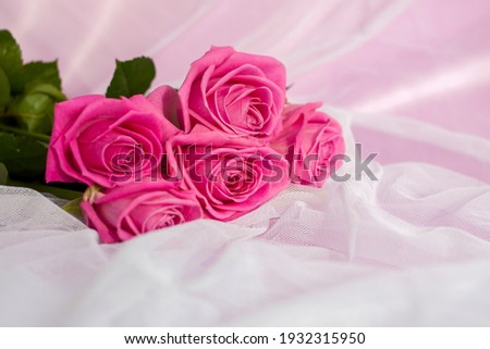 Composition with a bouquet of pink roses on a delicate fabric background. A holiday gift, pastel colors. Festive delicate background, birthday, wedding bouquet. Valentine's Day Greeting Card Design