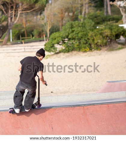 man jumping in a skatepark with a scooter