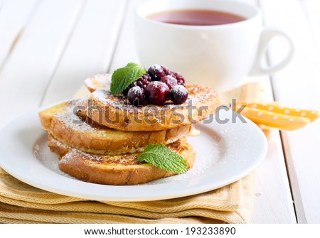 French toasts with icing sugar and berries, cup of tea Royalty-Free Stock Photo #193233890