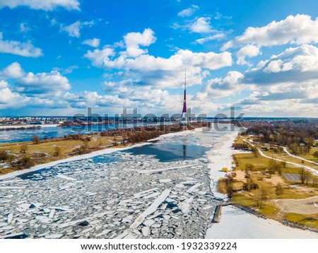 Beautiful panoramic aerial view photo from drone to The Riga Radio and TV Tower Riga. In the background zakusala, river Daugava and the city of Riga in winter