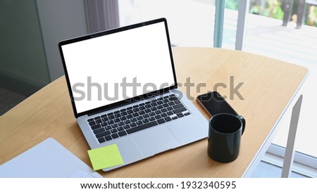 Wooden office desk with computer laptop, smart phone, document and coffee cup.