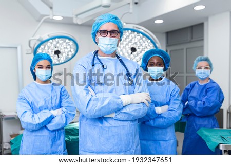 Portrait Of Multi-Cultural Medical Team Standing In operating theatre. Portrait of successful medical workers in surgical uniform in operation theater, ready for next operation.