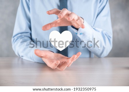 Businessman in shirt holding heart icon symbol .