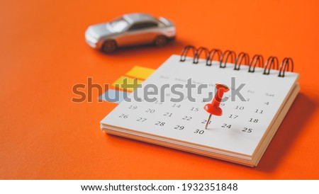 close up of red thumbtack on white page of calendar and blurred miniature silver car for business and finance background , new car, goal concept Royalty-Free Stock Photo #1932351848