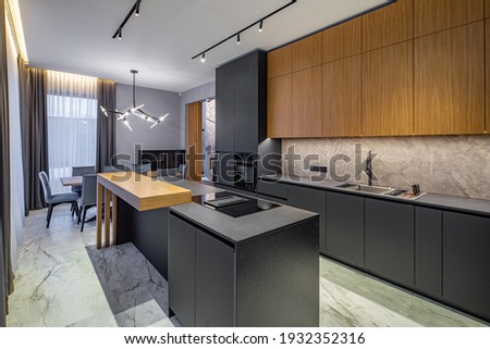 Modern interior of kitchen in luxury private house. Grey and wooden design. Marble floor. Panorama windows. Stylish kitchen set. Royalty-Free Stock Photo #1932352316