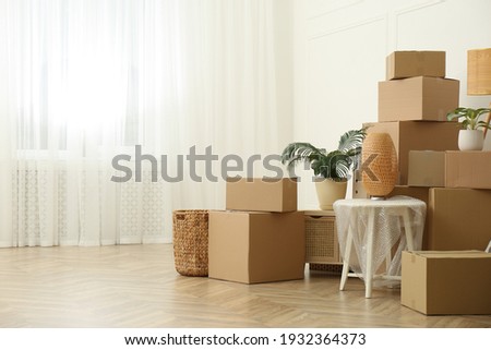 Cardboard boxes and household stuff indoors, space for text. Moving day Royalty-Free Stock Photo #1932364373