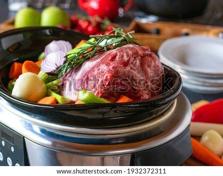 raw and uncooked Roast pork with root vegetables in a slow cooker Royalty-Free Stock Photo #1932372311
