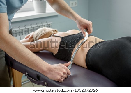 Chiropractic treatment using muscle scraping IASTM tool Royalty-Free Stock Photo #1932372926