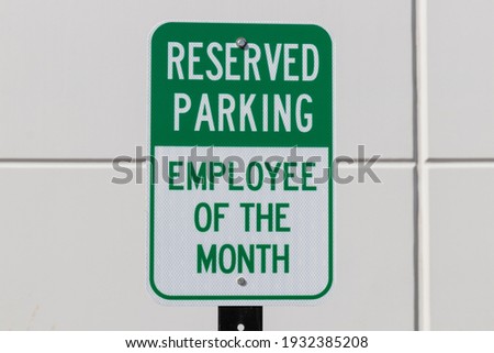 Reserved Parking for the Employee of the Month sign in white and green text.
