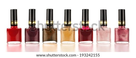 Row of varied red tone nail polish bottles over a white background