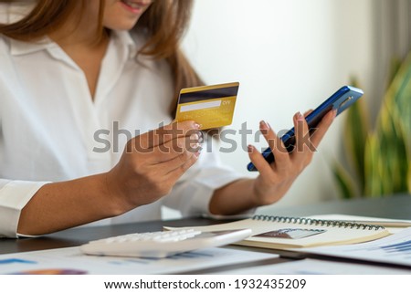 woman holding credit card and using smartphone at home. Businessman or entrepreneur working in office. Online shopping, internet banking, store online, payment, spending money, e-commerce concept.